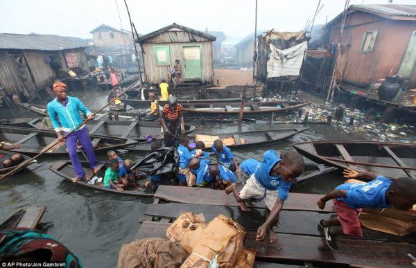•Pupils alighting from canoes on the floating slum